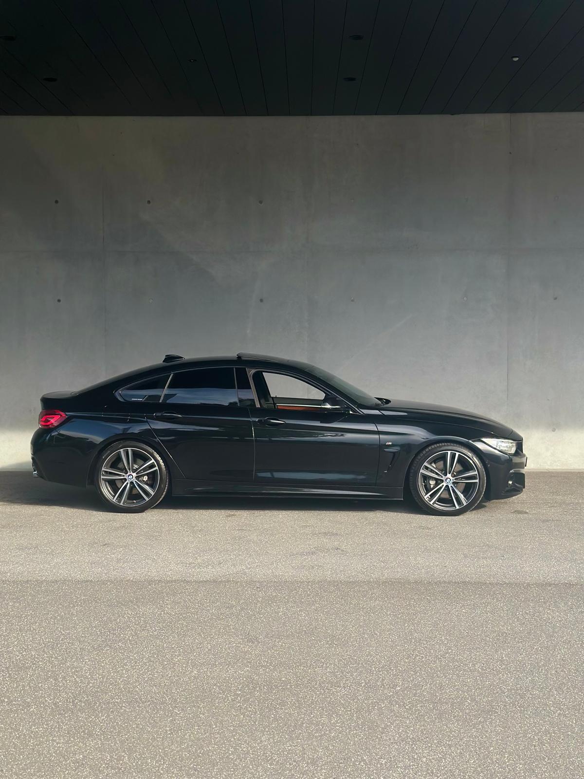 BMW 435i Gran Coupé side profile in front of a concrete wall