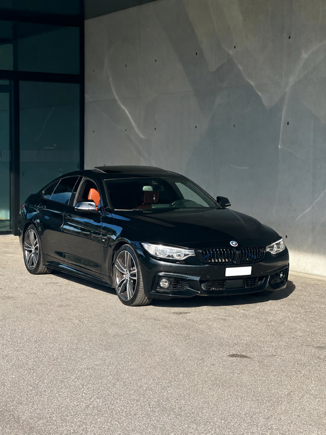 BMW 435i Gran Coupé front three-quarter view in front of a concrete wall
